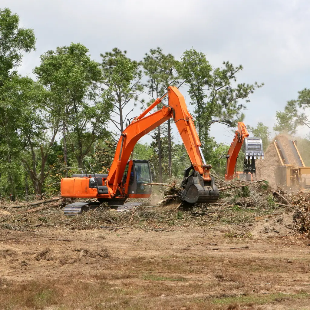 Land clearing in progress with professional-grade excavators removing trees and debris – Outta Bounds Excavation specializing in site preparation and forestry mulching services.