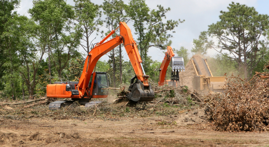 Excavators performing brush shredding and land clearing on a wooded site in Northeast Texas