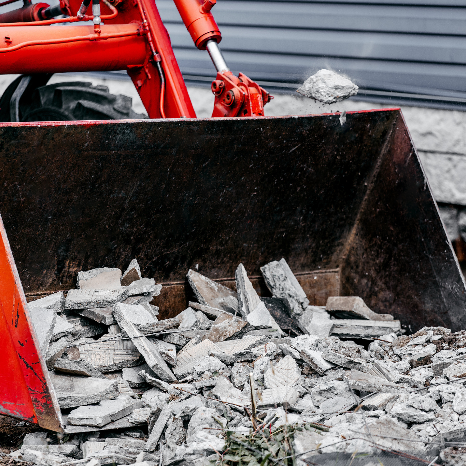 Loader bucket filled with broken concrete during demolition – Outta Bounds Excavation handling safe and efficient concrete removal services.