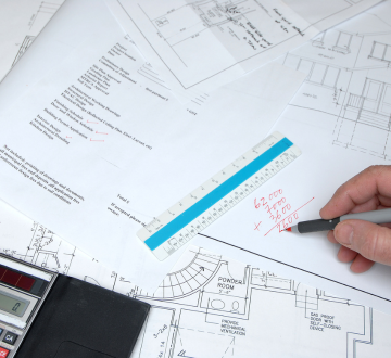 Engineer reviewing construction blueprints and site layout plans – Outta Bounds Excavation ensuring precision in project planning and execution.