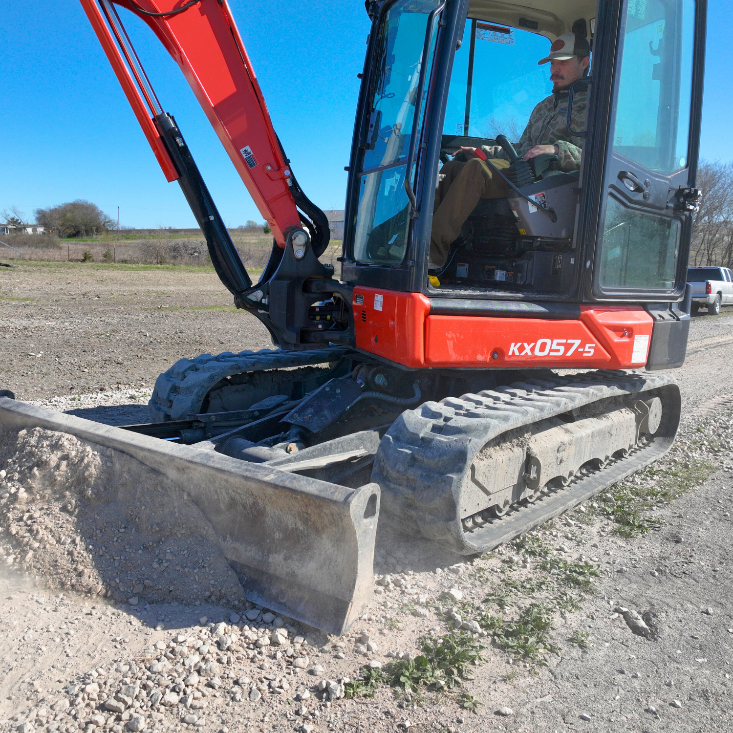 Operator using a compact mini excavator for grading work on a rural Texas job site – Outta Bounds Excavation delivering precise excavation and land shaping services.
