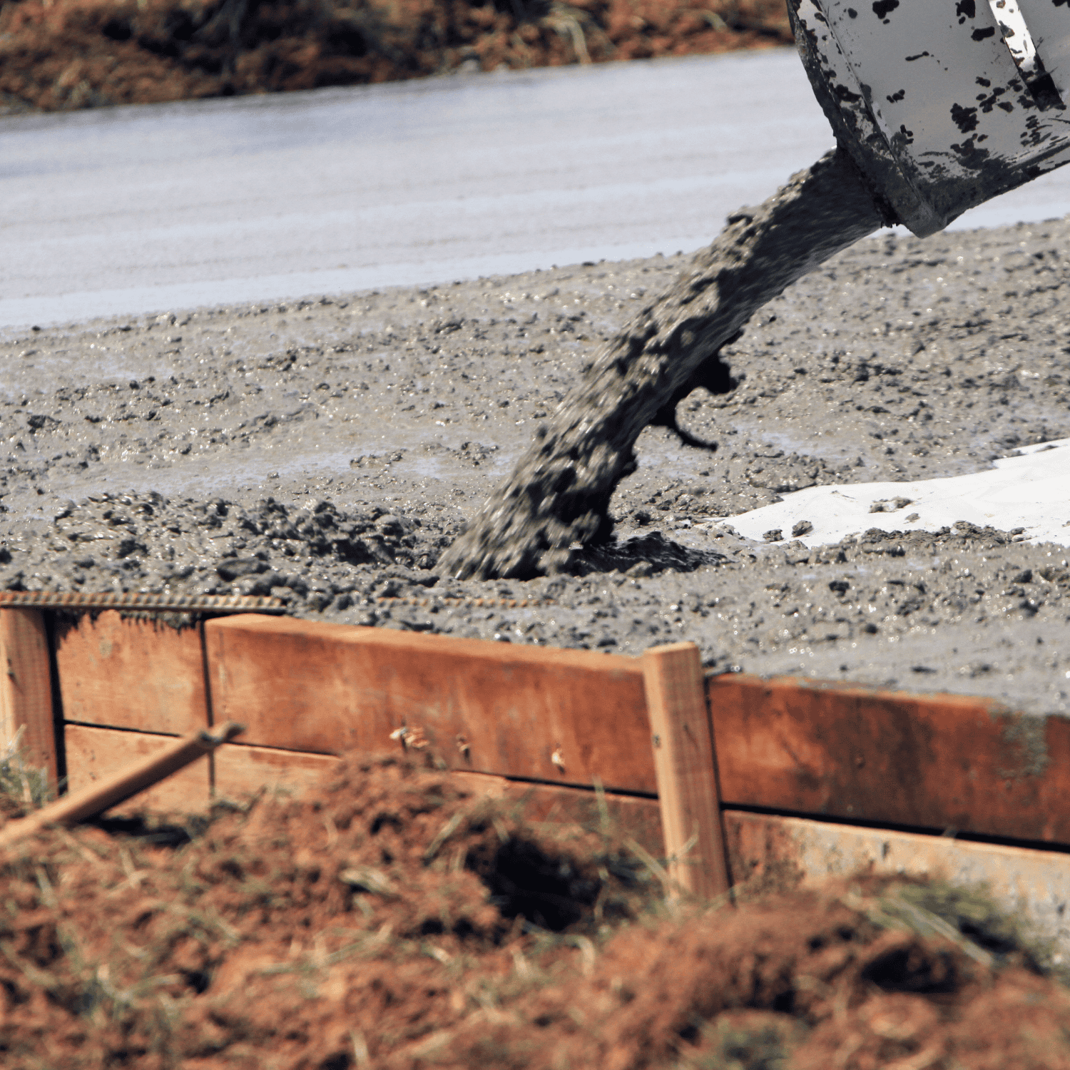 Fresh concrete being poured into a prepared form for a foundation slab – Outta Bounds Excavation delivering reliable groundwork and site prep services.